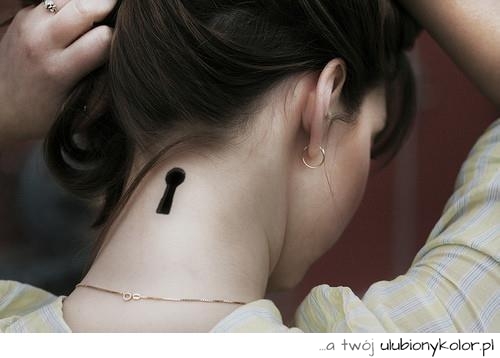 Tatuaż na karku w kształcie dziurki od klucza.